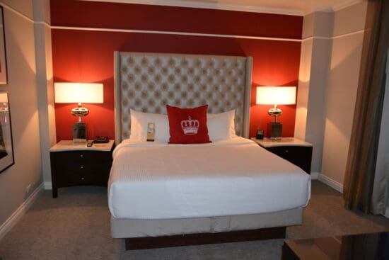 a bed with a red headboard and a lamp on the side