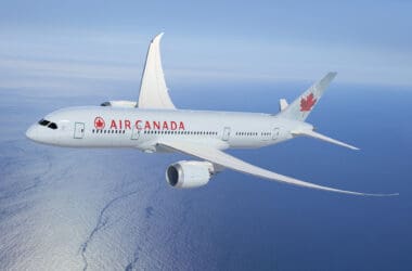 a white airplane flying over water