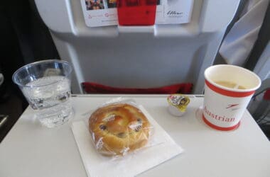 a bun and a cup of water on a table