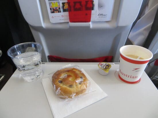 a bun and a cup of water on a table