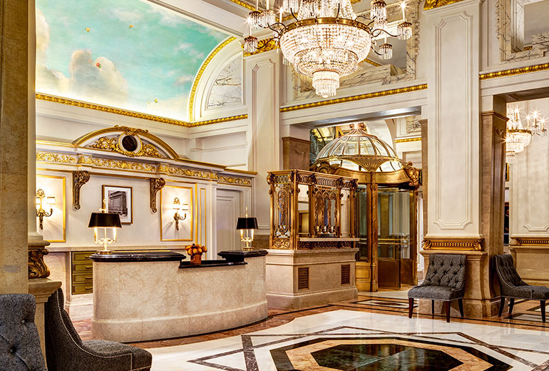 a lobby with a chandelier and a reception desk