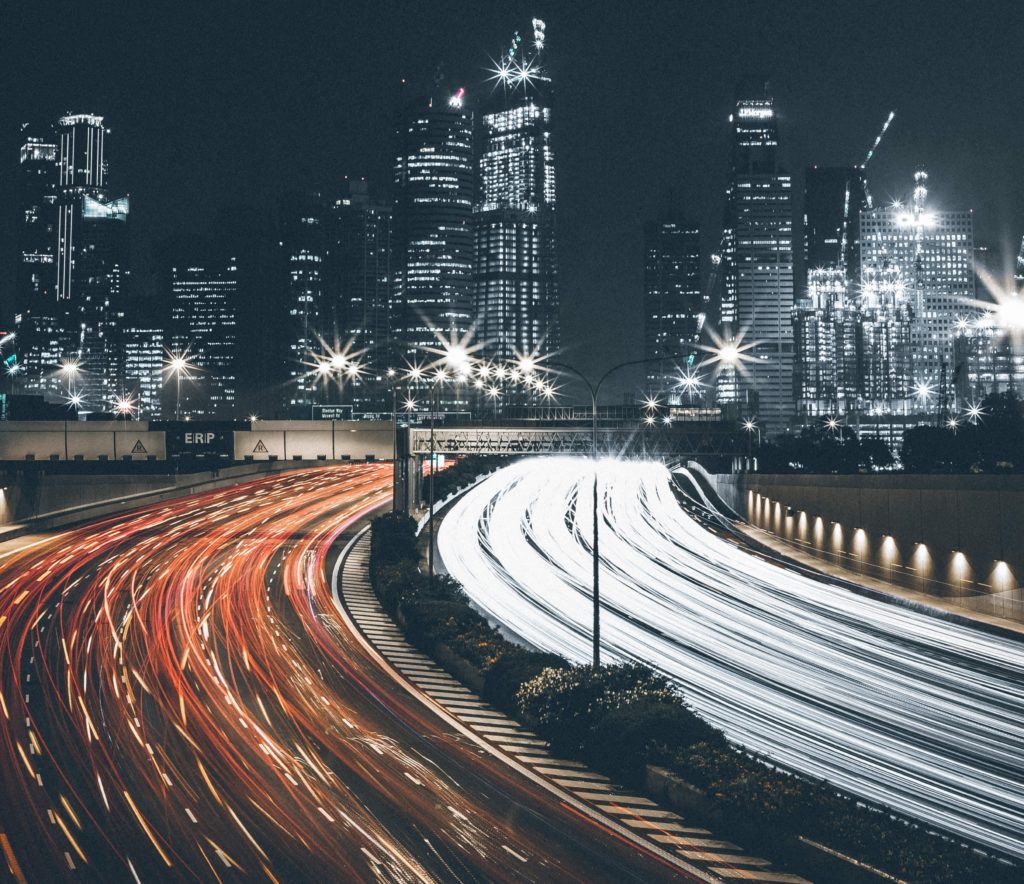 a city skyline at night with a freeway