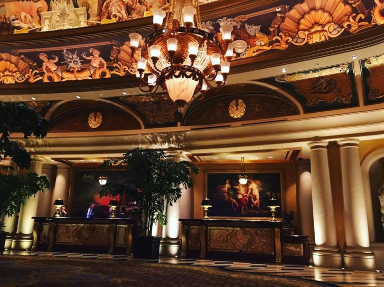 a lobby with a chandelier and a painting on the ceiling