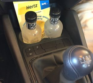 a car interior with a shift lever and bottles of liquid