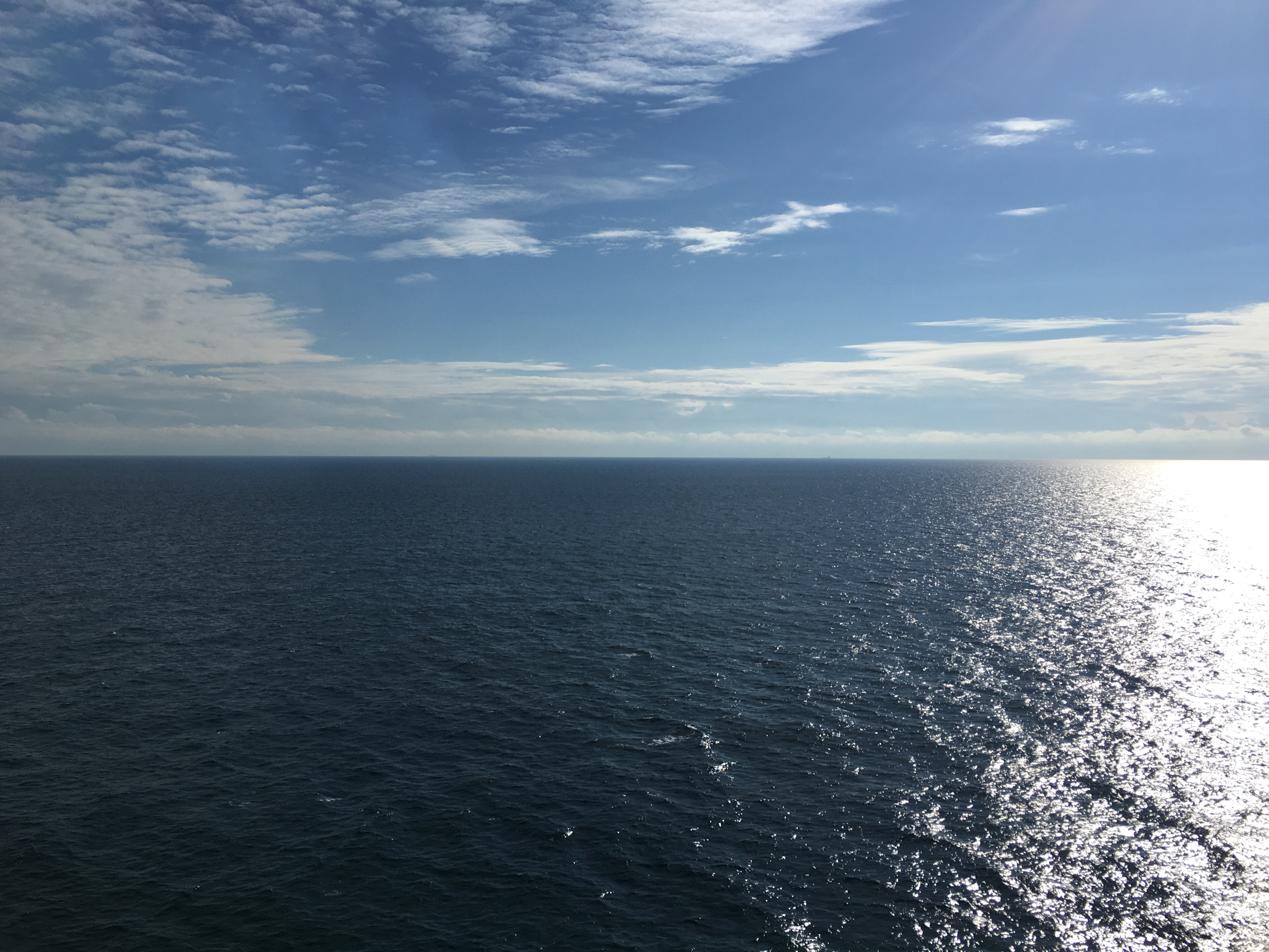 a body of water with blue sky and clouds