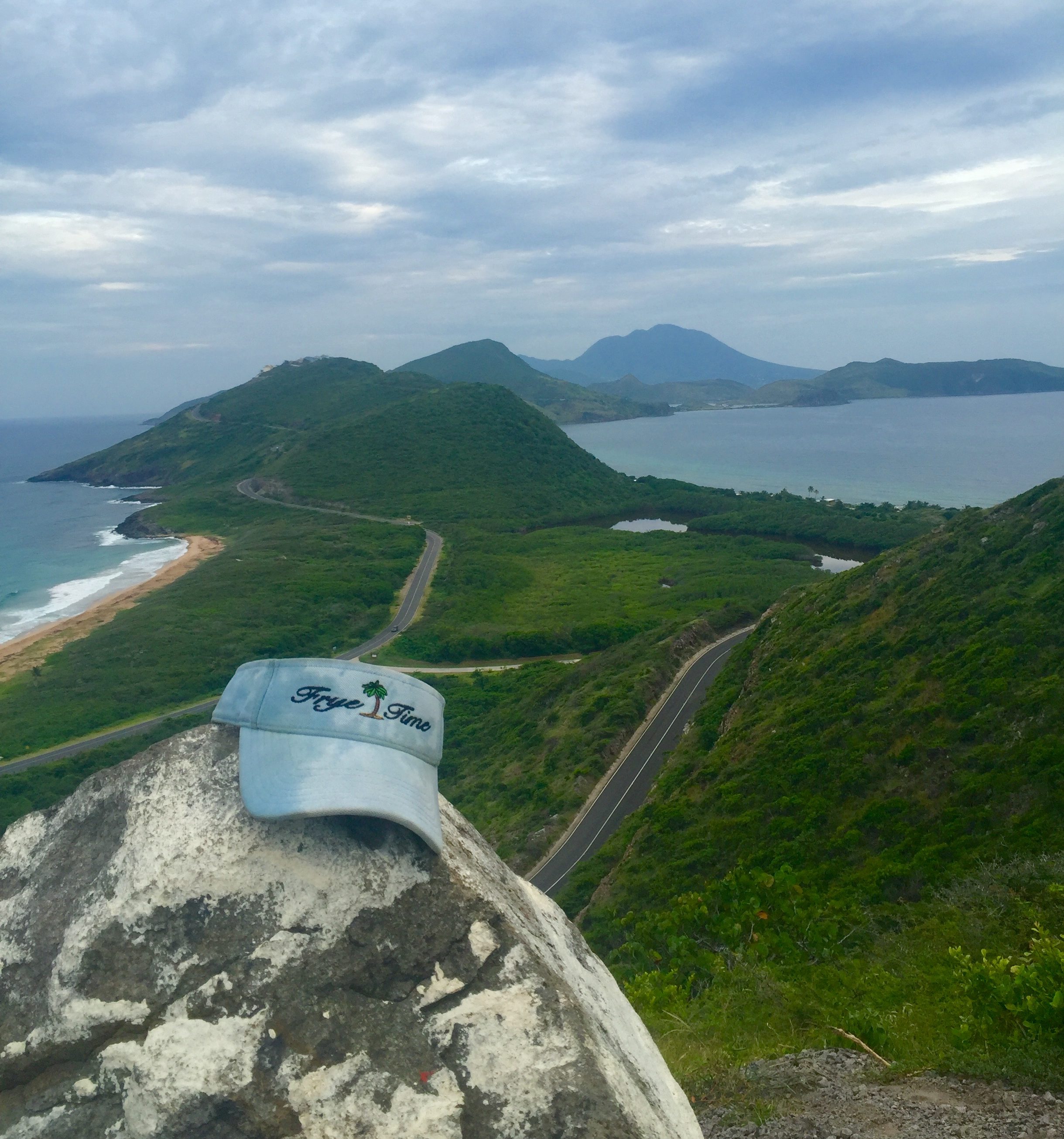 a hat on a rock with a road and mountains in the background