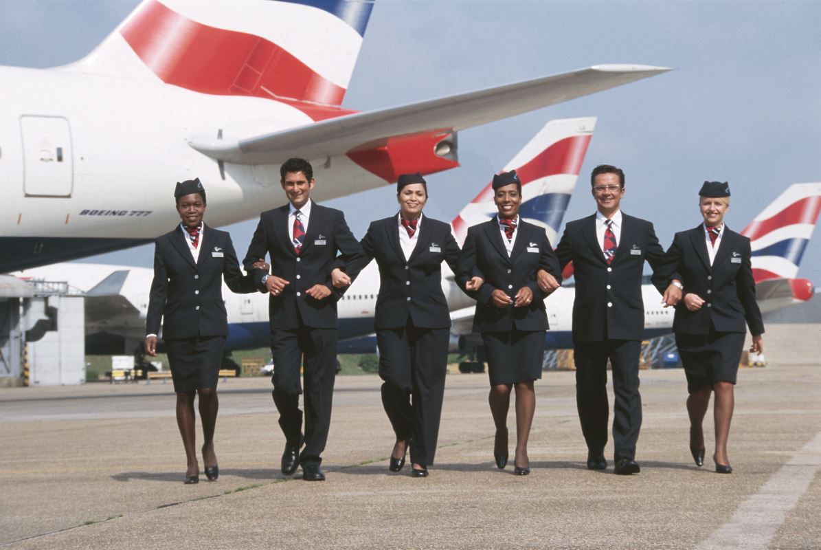 a group of people in uniform walking in front of an airplane