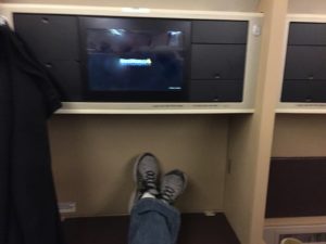 a person's feet on a shelf with a television