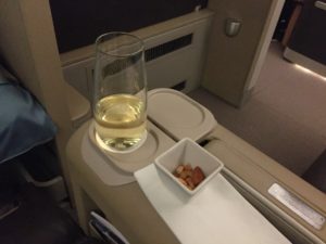 a glass of wine on a tray with food in it