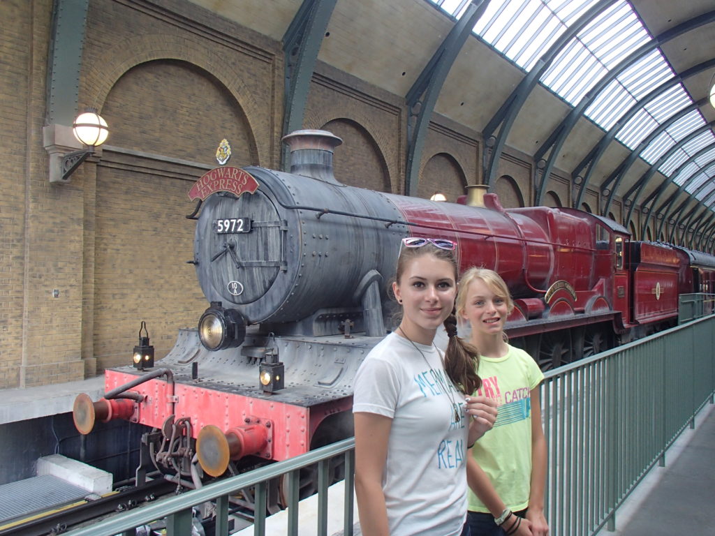 two girls standing in front of a train