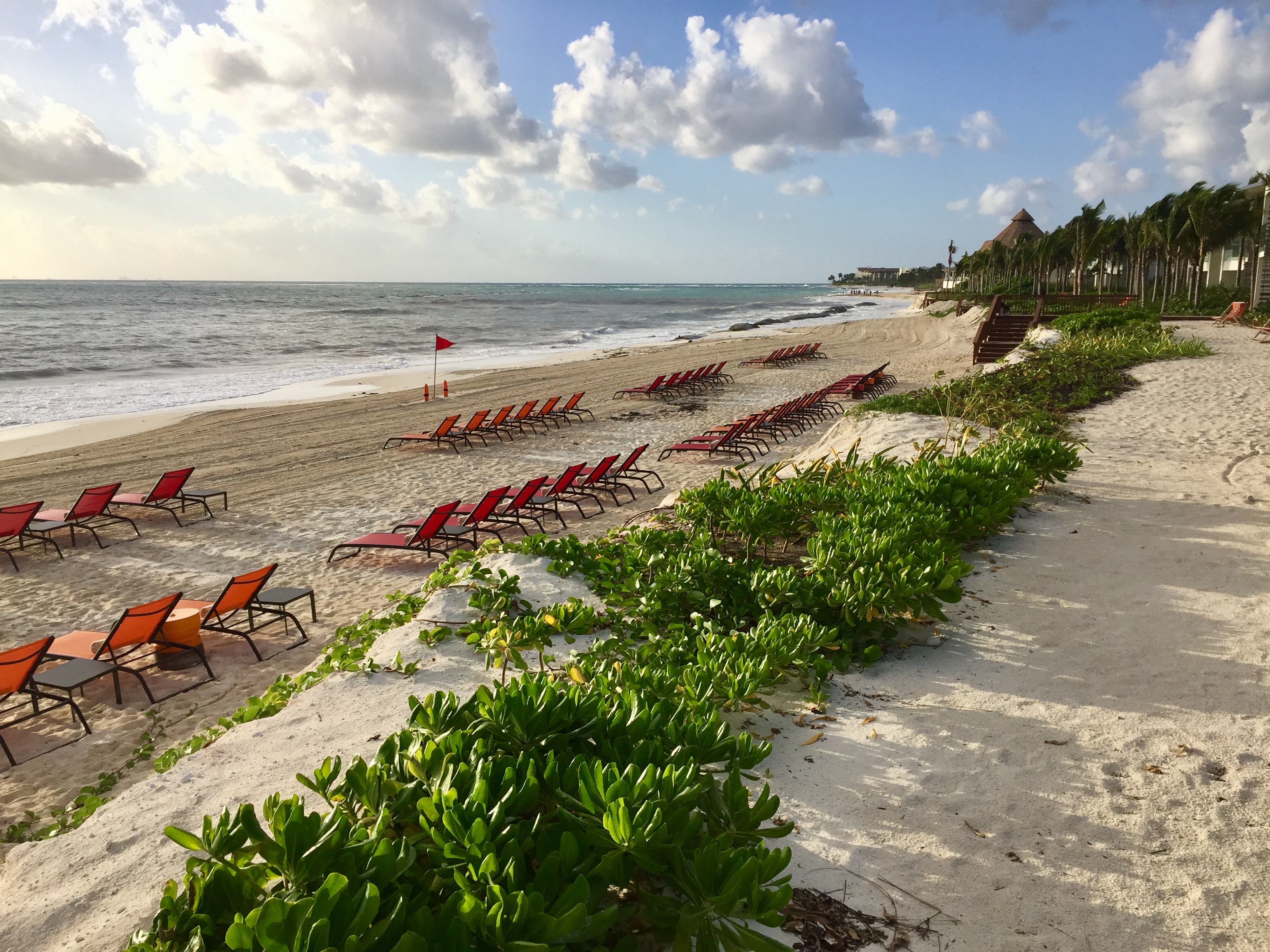 a beach with chairs and a flag