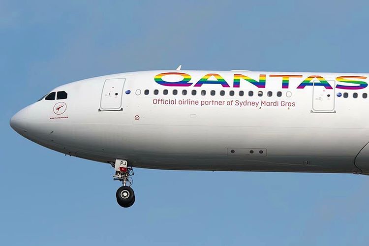 a white airplane with rainbow text on it