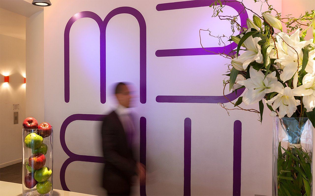 a man walking in front of a wall with flowers