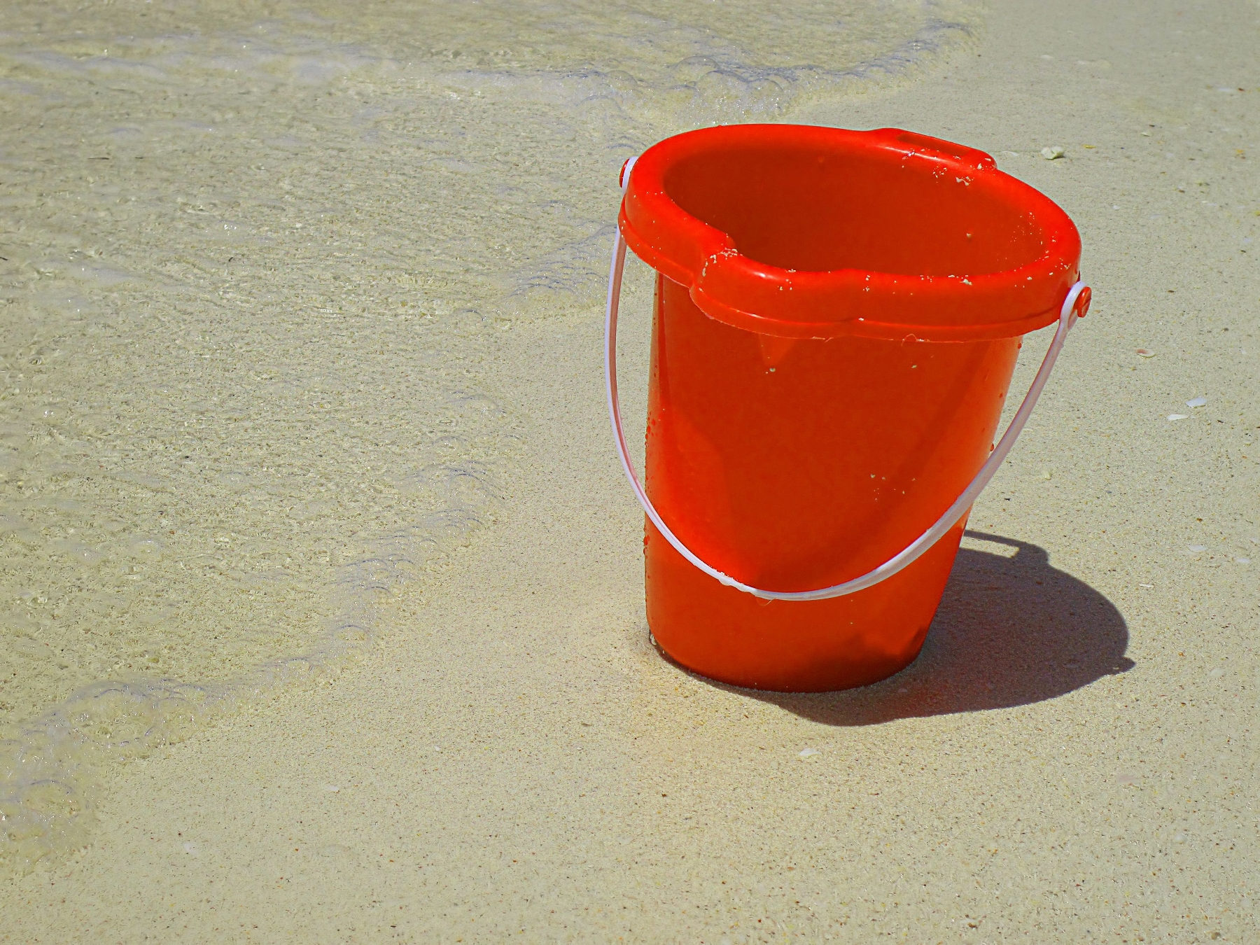 a red bucket on sand