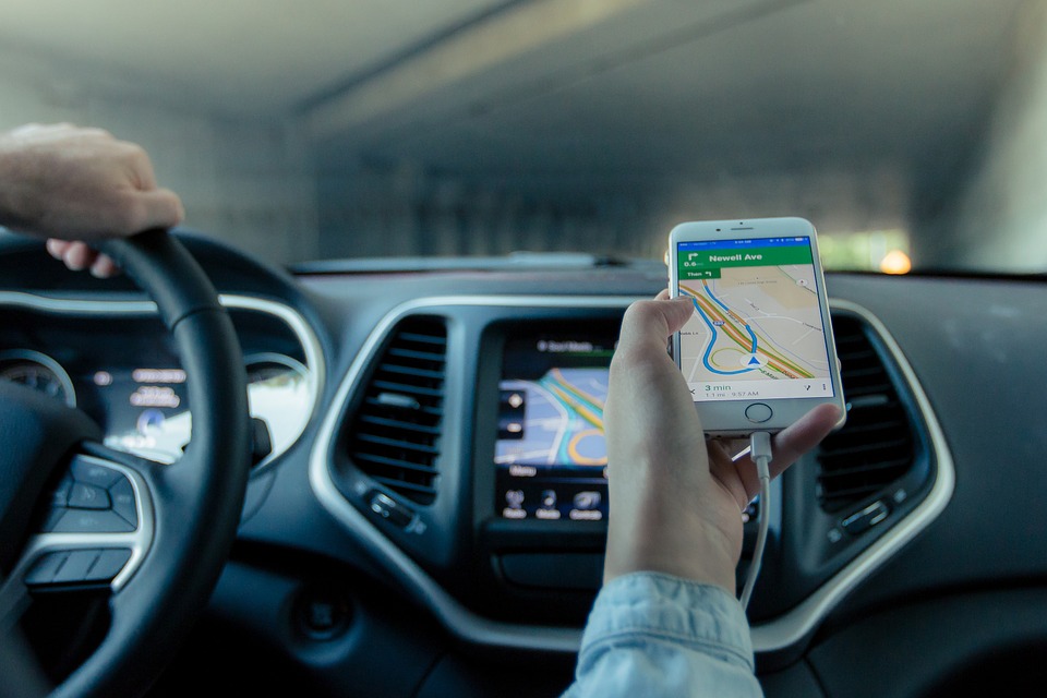 a person holding a phone in front of a car