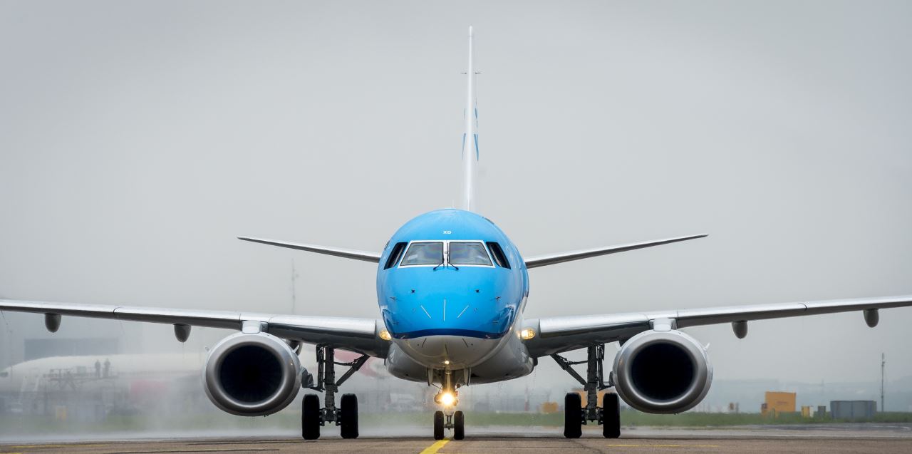 a blue and white airplane on a runway