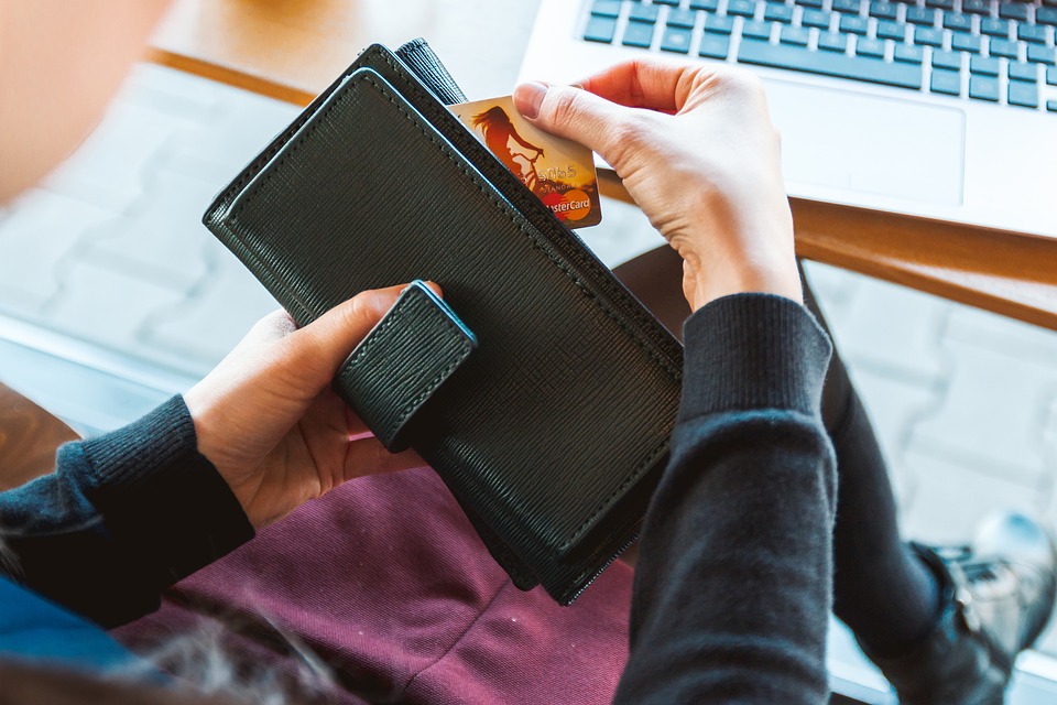 a person holding a wallet with a credit card in it