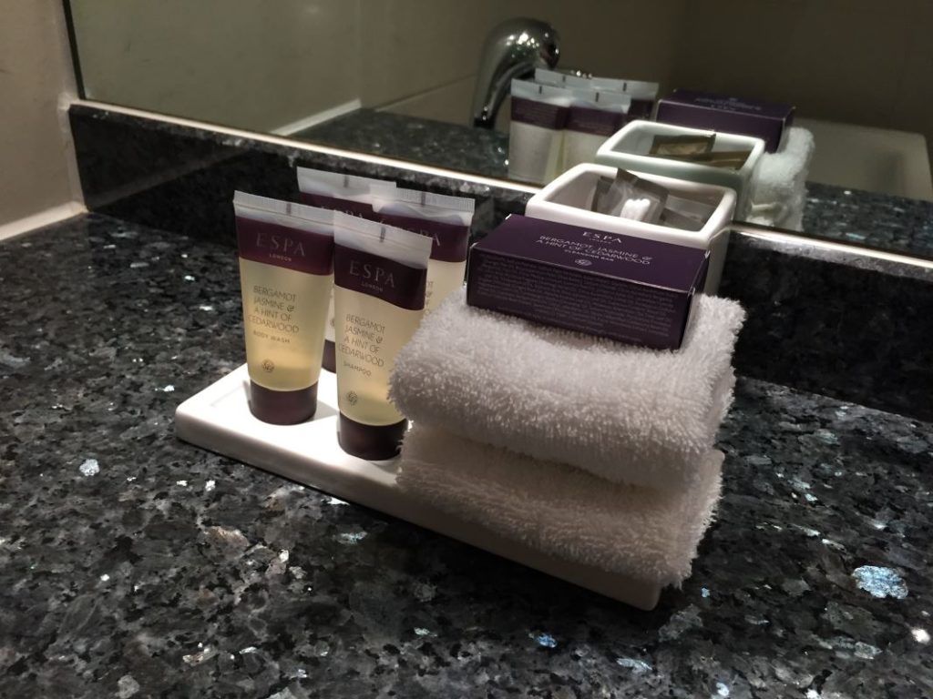 a group of small bottles of shampoo and towels on a counter