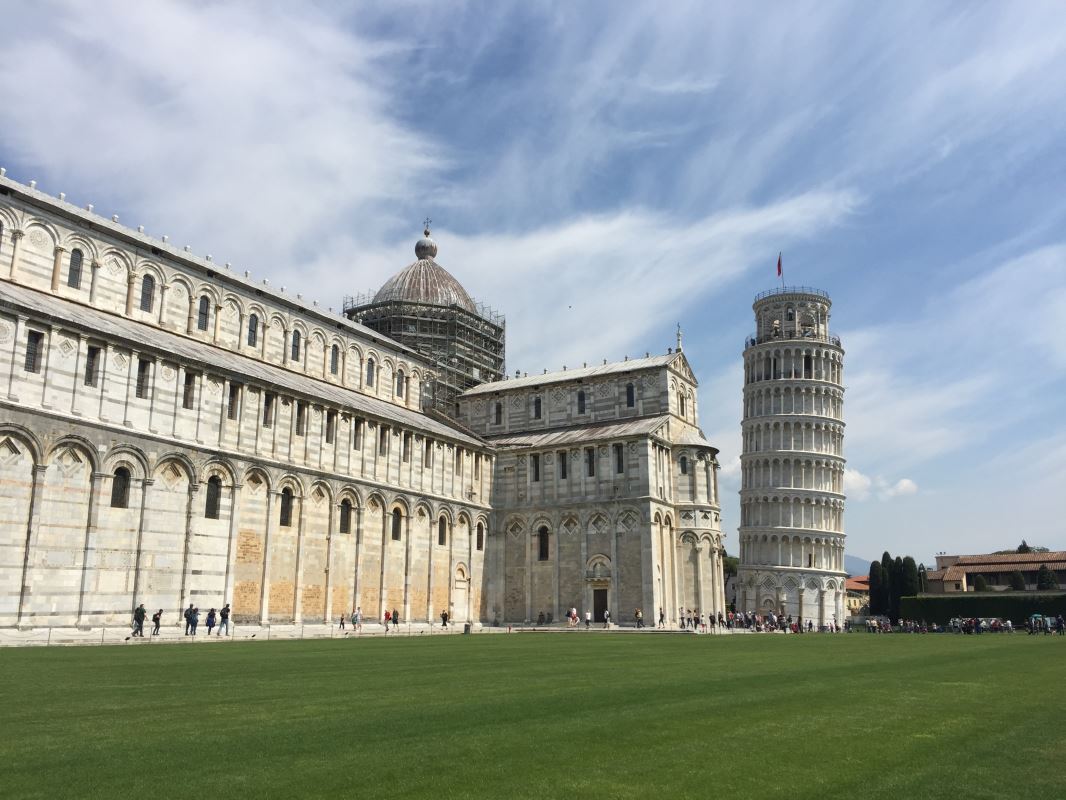 a grass field with a building and a tower