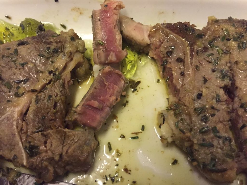 a plate of meat with herbs on it