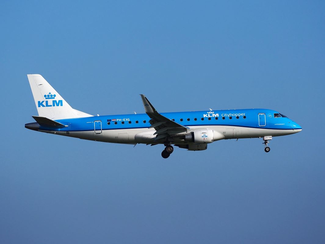 a blue and white airplane flying in the sky