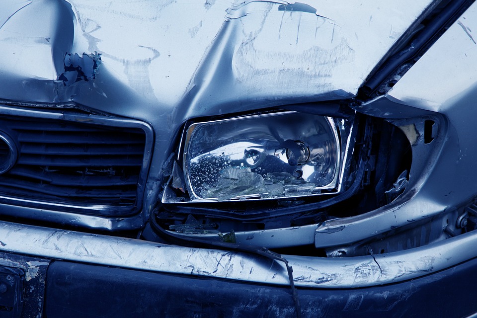 a front end of a car with a damaged headlight