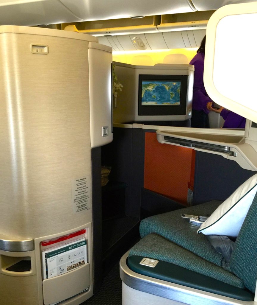 a seat and a screen on the back of a plane