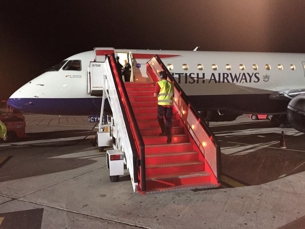 a man walking up stairs to an airplane