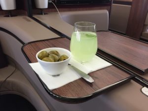 a bowl of olives and a drink on a tray