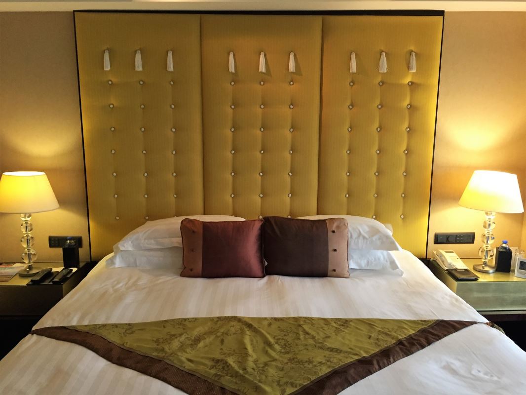 a bed with pillows and a large headboard