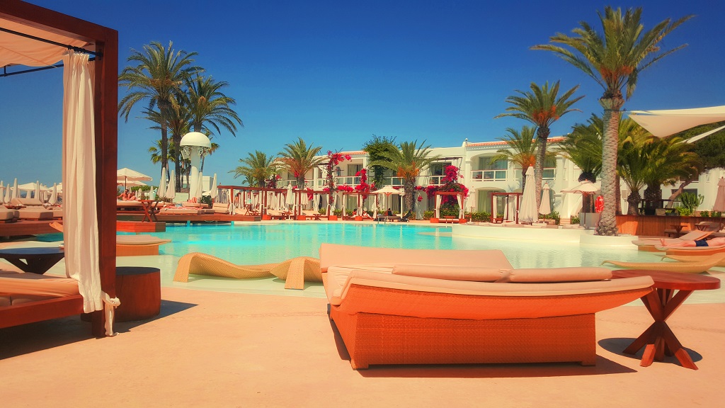 a pool with lounge chairs and palm trees