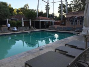 a pool with lounge chairs and a building