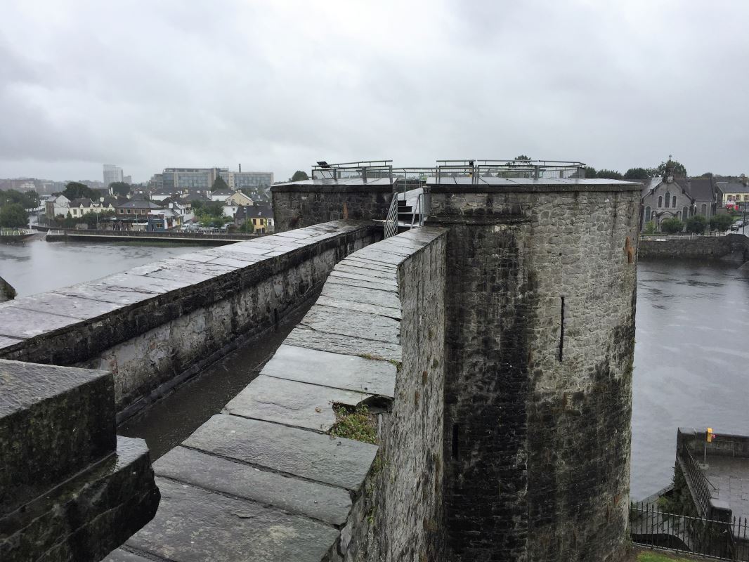 a stone wall with a bridge over water