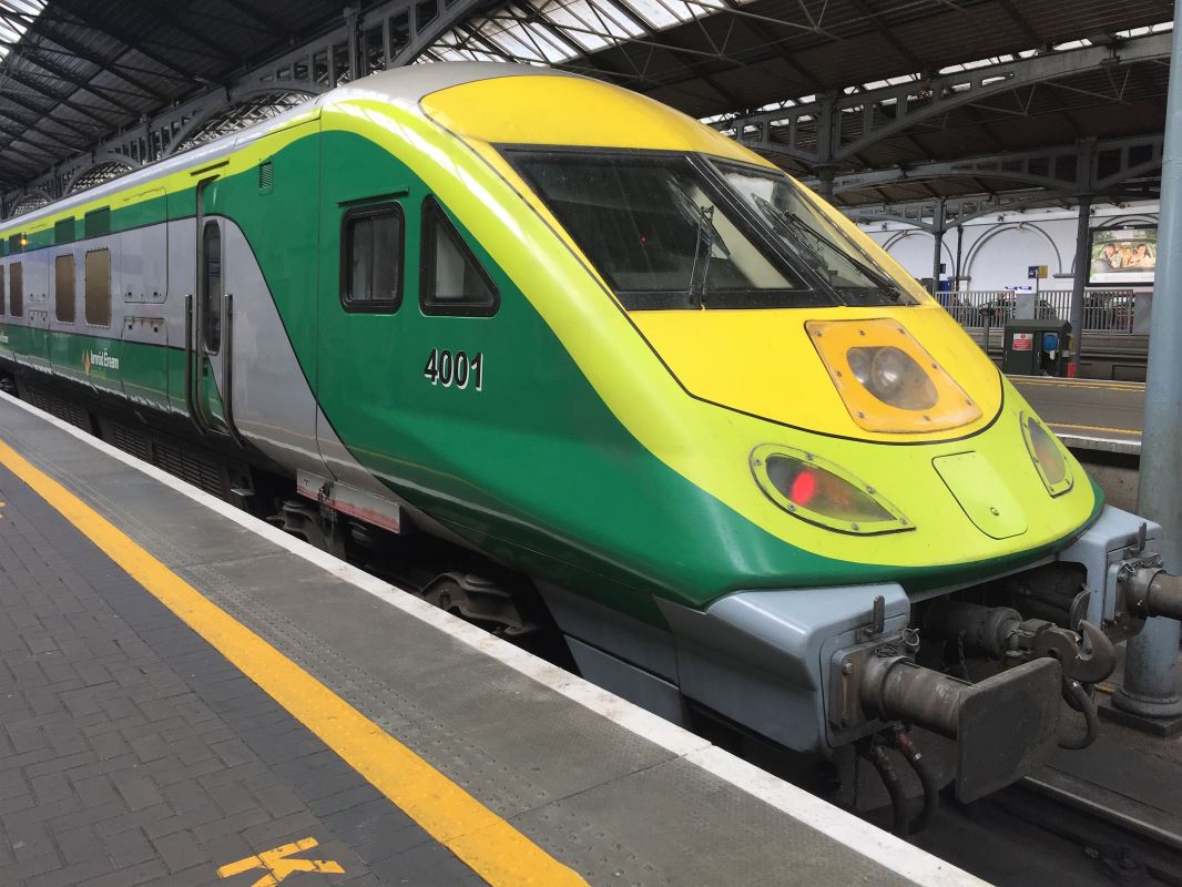 a green and yellow train at a train station