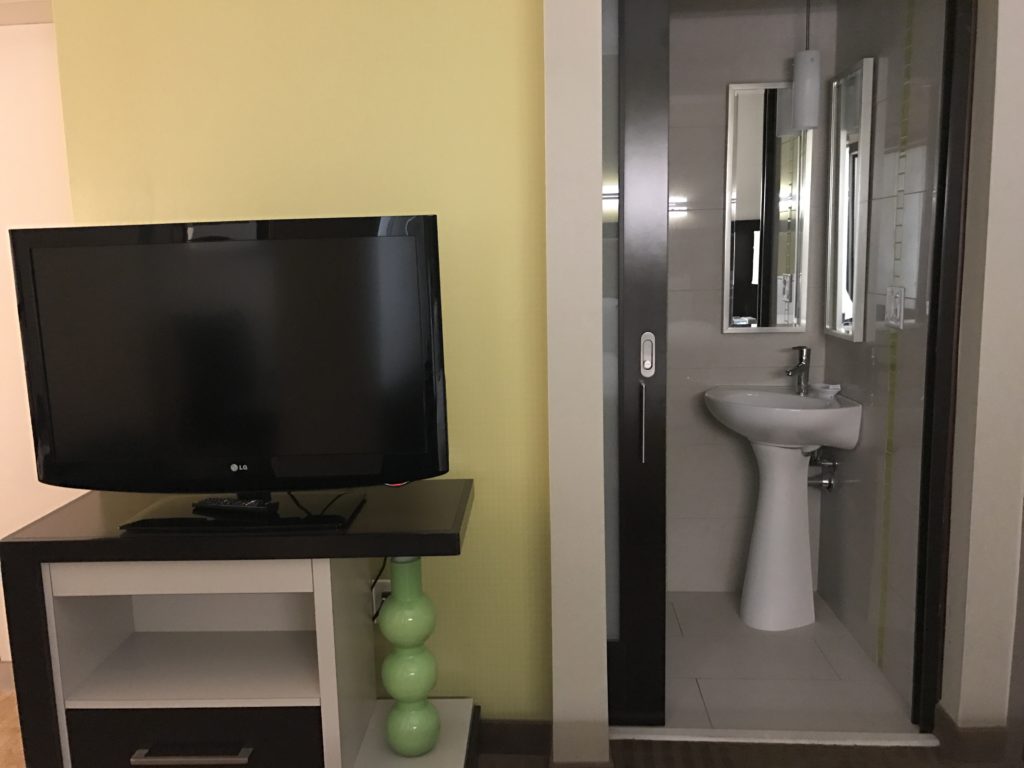 a tv on a stand next to a sink