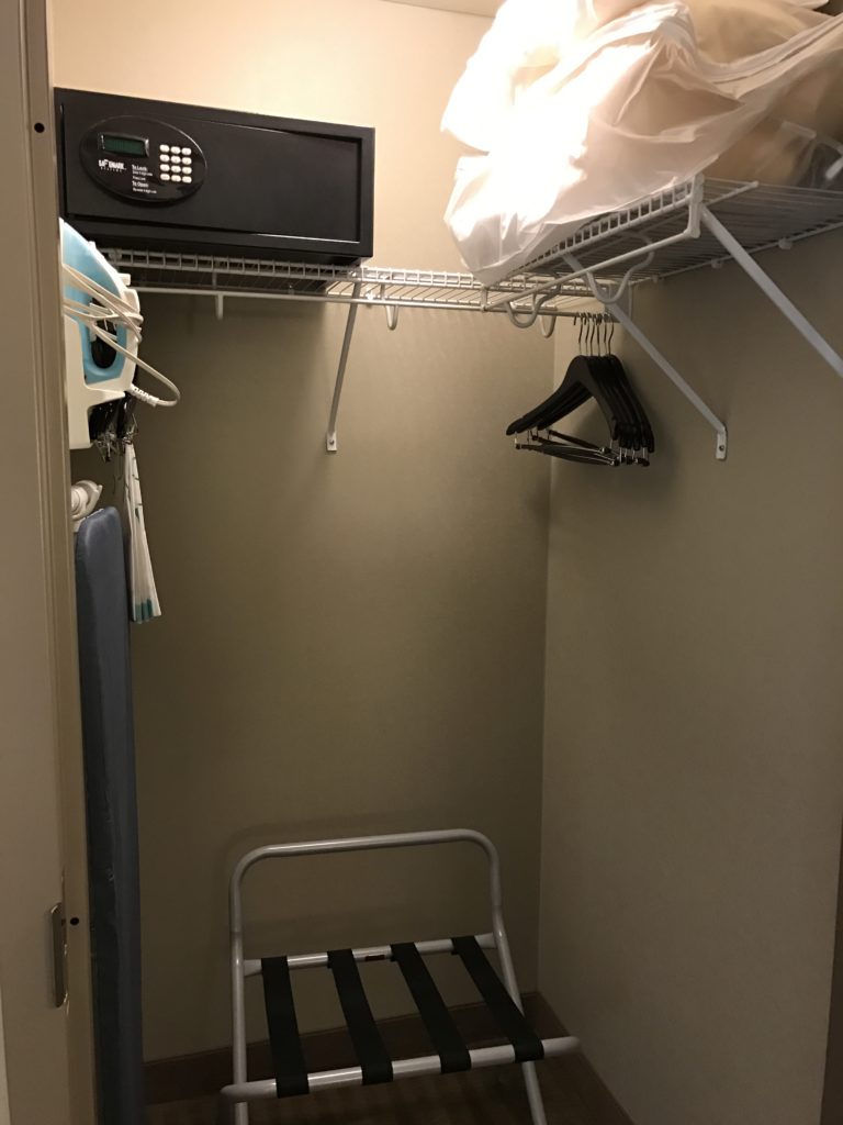 a small closet with a black metal chair and swingers