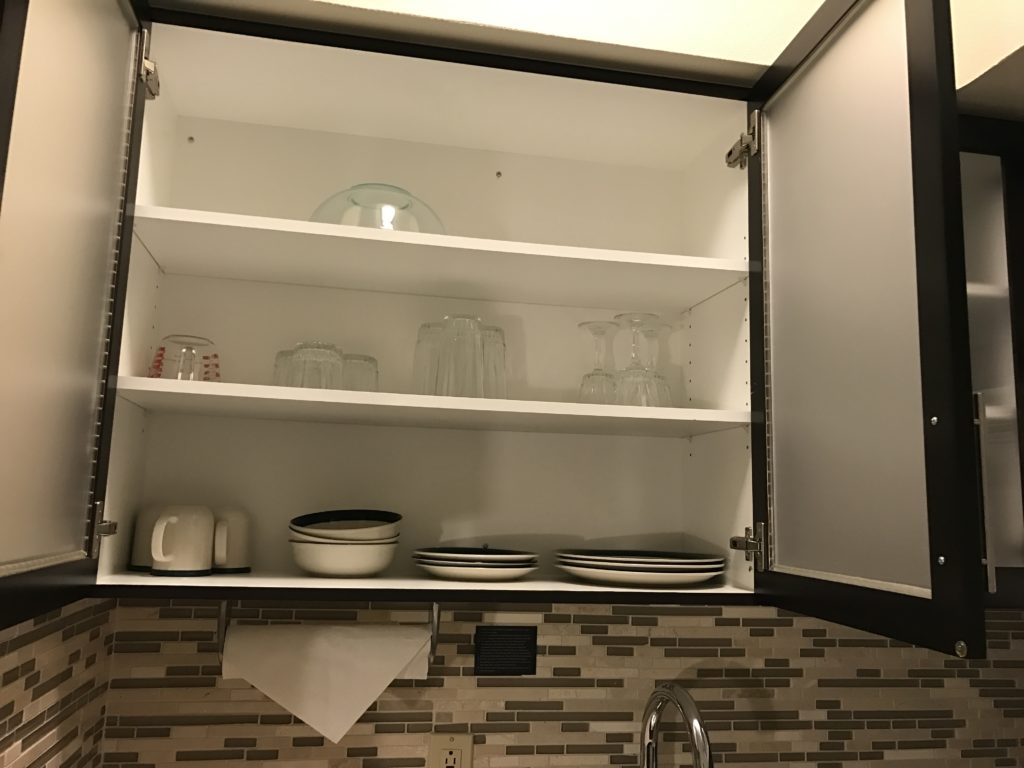 a kitchen cabinet with shelves and plates