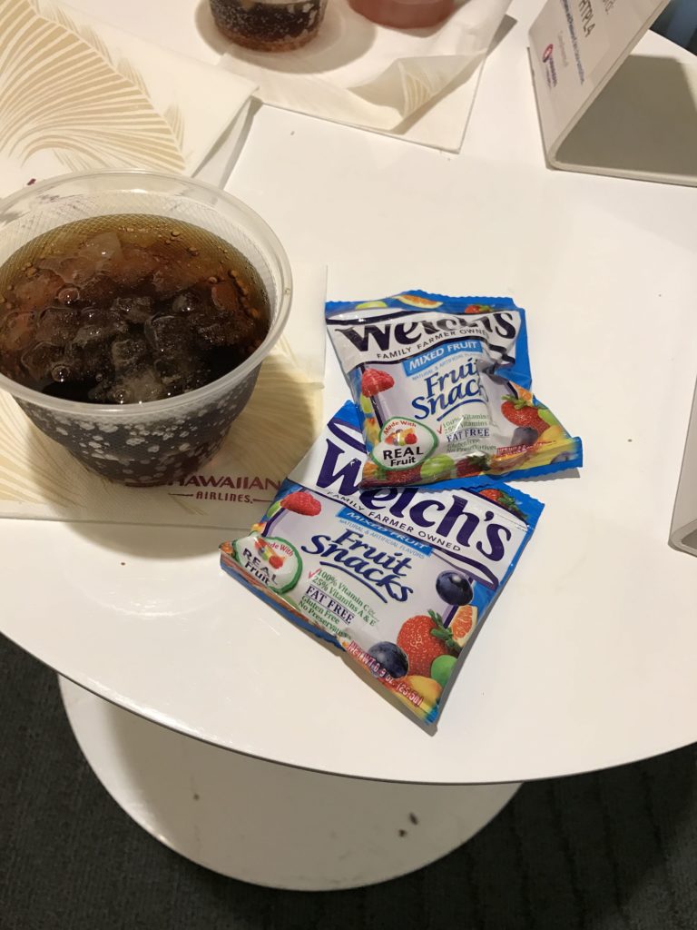 a cup of fruit snack and a drink on a table