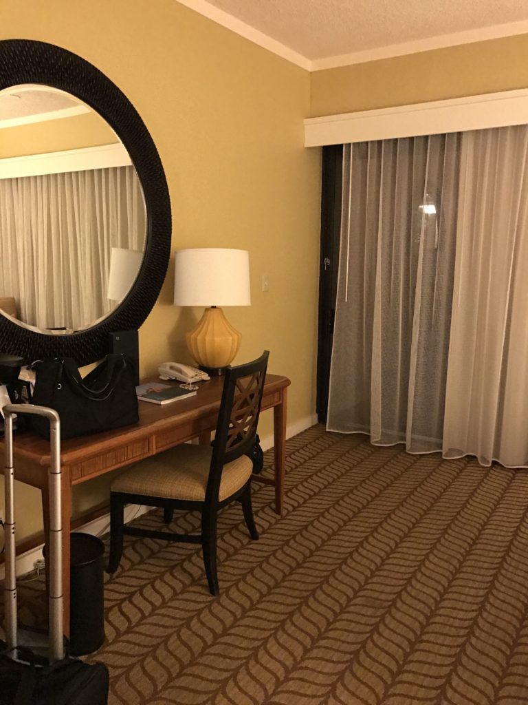 a room with a desk and chair and a mirror