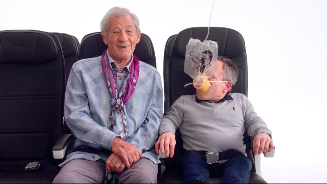 a man sitting next to a man with a tube in his mouth