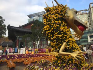 a statue of a dragon with flowers