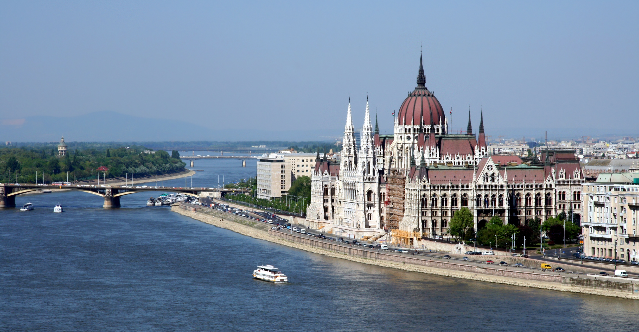 a large building with a dome and spires on a river