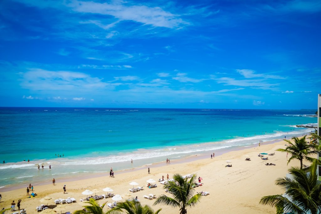 a beach with people and umbrellas