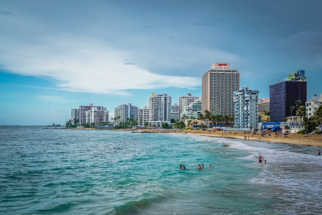 a beach with buildings and people in the water