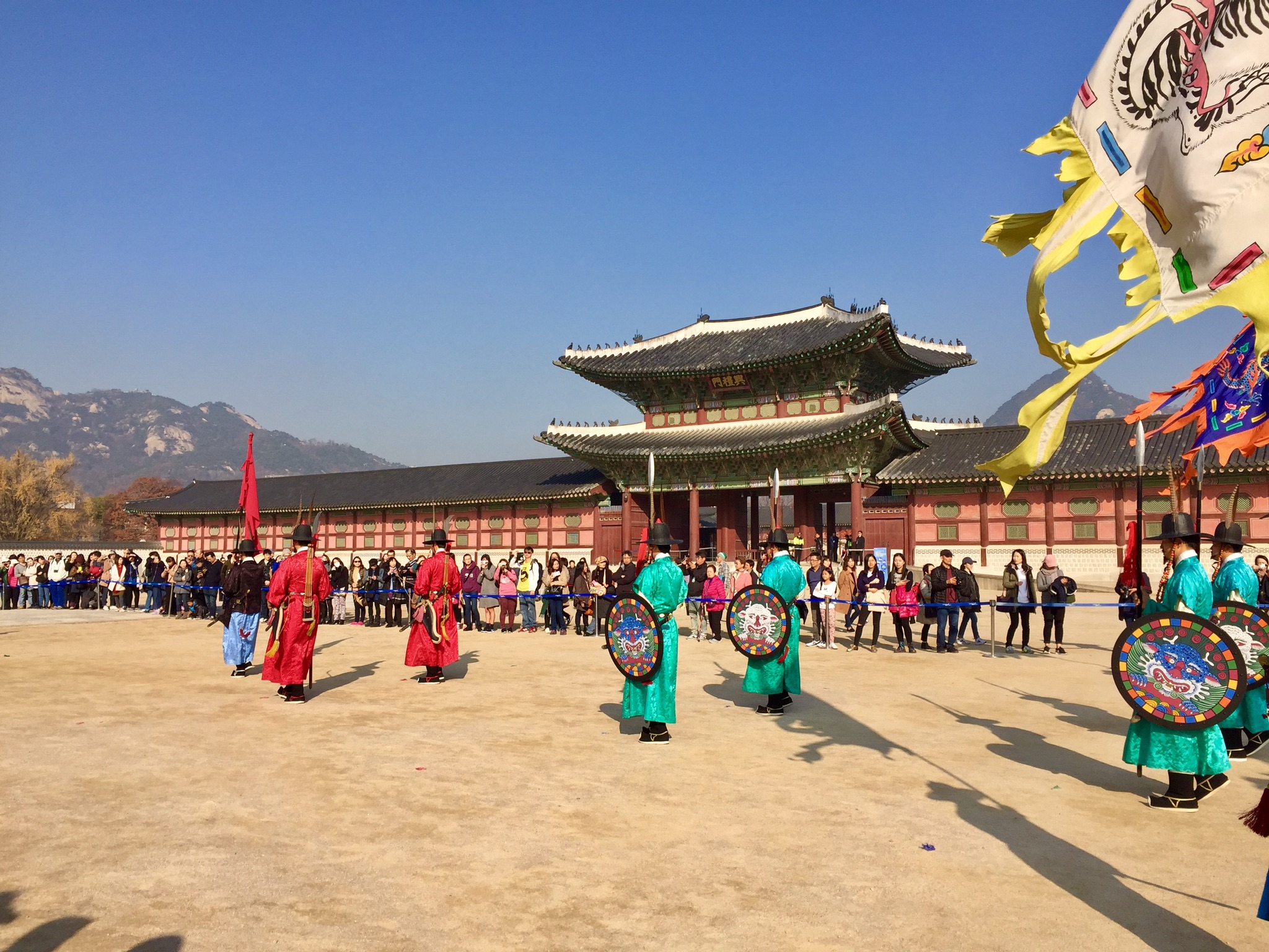 a group of people in traditional clothing in front of Gyeongbokgung