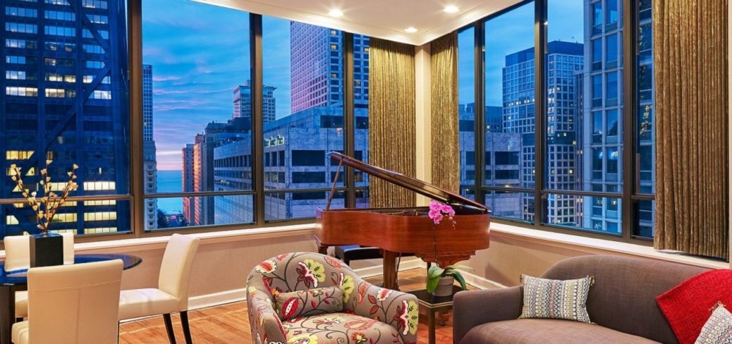 a room with a grand piano and chairs