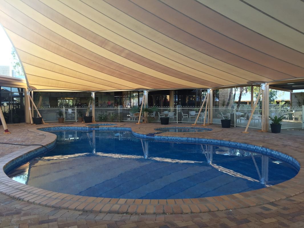 a pool with a white and tan tent