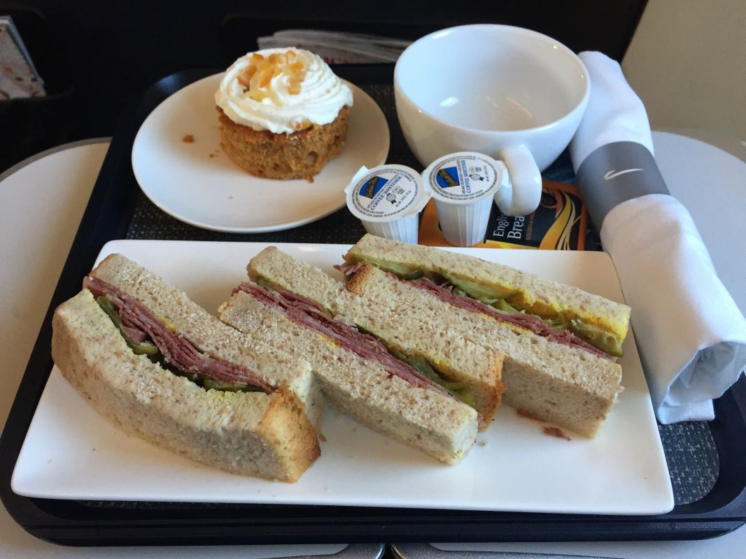 a plate of sandwiches and cupcake on a tray