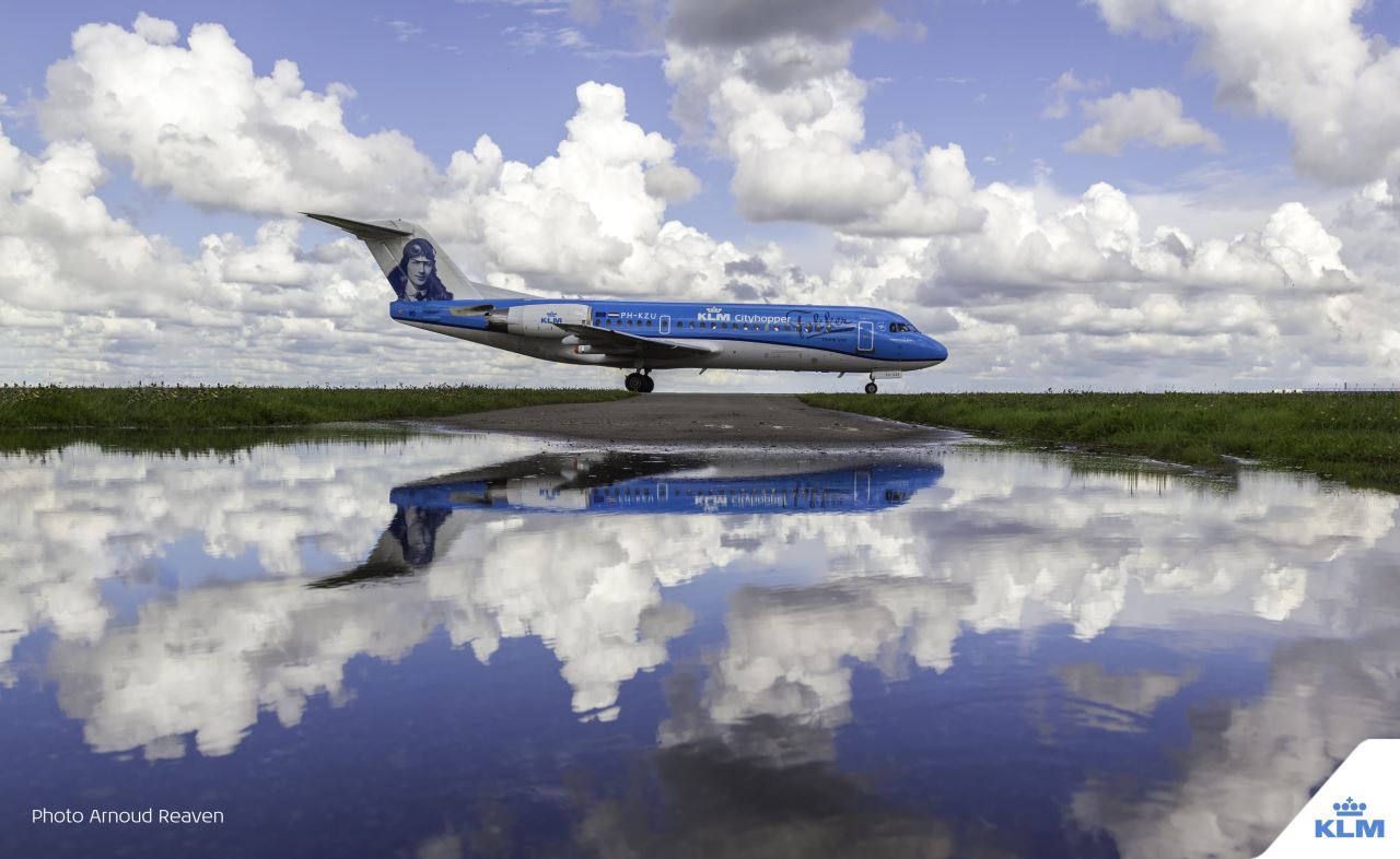 a blue and white airplane on a runway