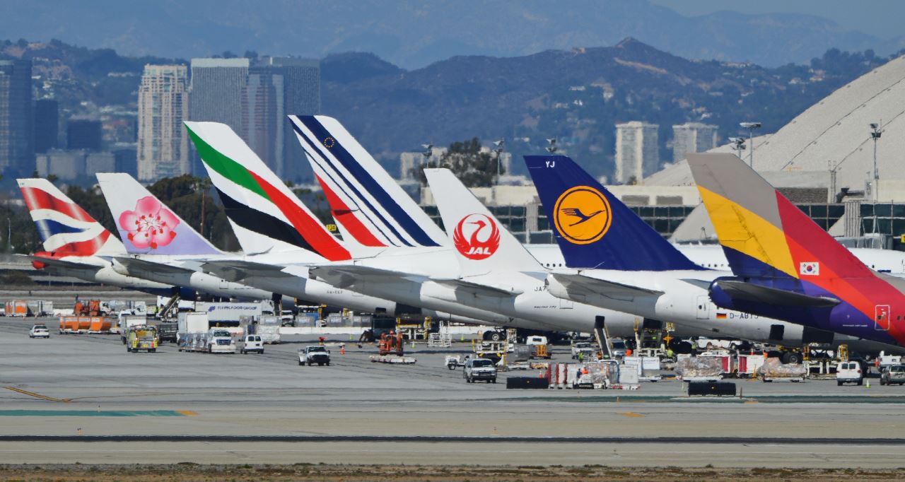 a group of airplanes parked at an airport